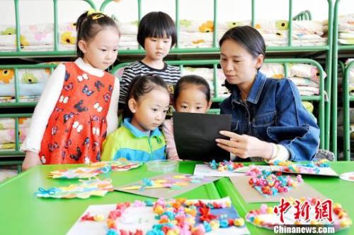  资料图：甘肃张掖民乐县第一幼儿园大班的小朋友为老师制作爱心卡片。张渊摄